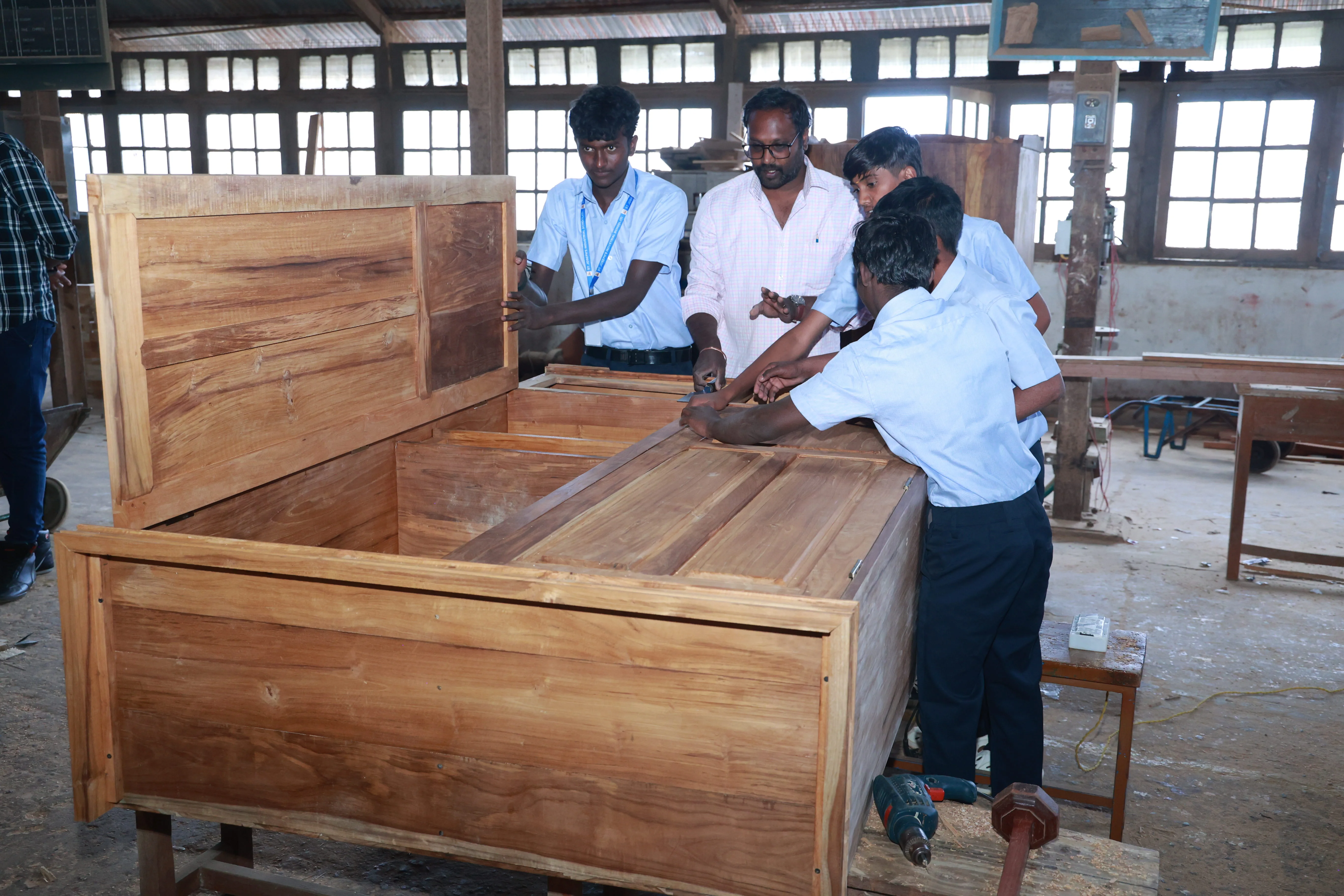 Carpentry students assembling wooden bed at St. Joseph ITI